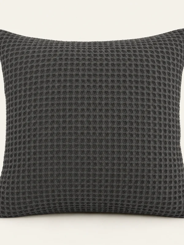 Charcoal Waffle Cushion Cover on a warm ivory background — AI-generated design illustration