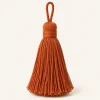 Rust Cotton Tassel on a warm ivory background — AI-generated design illustration